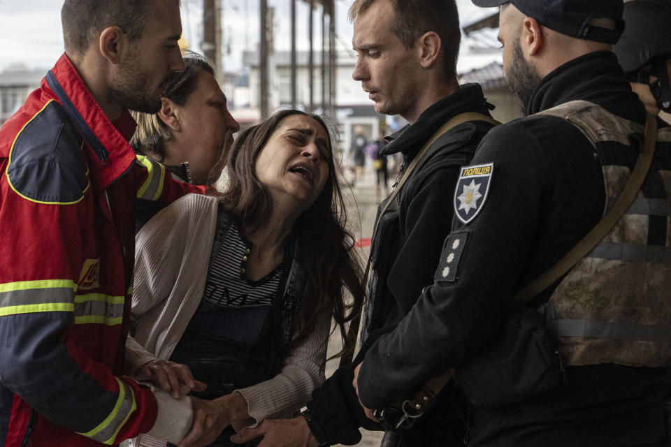 Sabina, centre, cries after her husband Artem Pogorelets was killed by Russian shelling at Barabashovo market in Kharkiv, Ukraine, Thursday, July 21, 2022. (AP Photo/Evgeniy Maloletka)