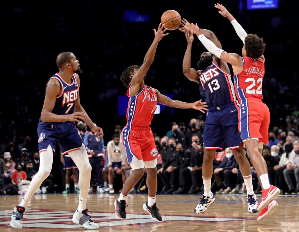 The Nets' James Harden, 13, pursues a loose ball with the Sixers' Matisse Thybulle, 22, and Tyrese Maxey as Brooklyn's Kevin Durant watches.