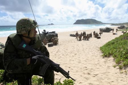 A soldier with the Japan Maritime Self-Defense Force sets up a perimeter defense during a simulated beach assault at Marine Corps Base Hawaii with the 3rd Marine Expeditionary Unit during the multi-national military exercise RIMPAC in Kaneohe, Hawaii, July 30, 2016. REUTERS/Hugh Gentry/File photo