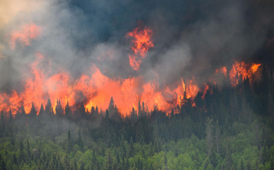 Flames reach upwards along the edge of a wildfire as seen from a Canadian Forces helicopter surveying the area near Mistissini, Quebec, Canada June 12, 2023. / Credit: CANADIAN FORCES via Reuters