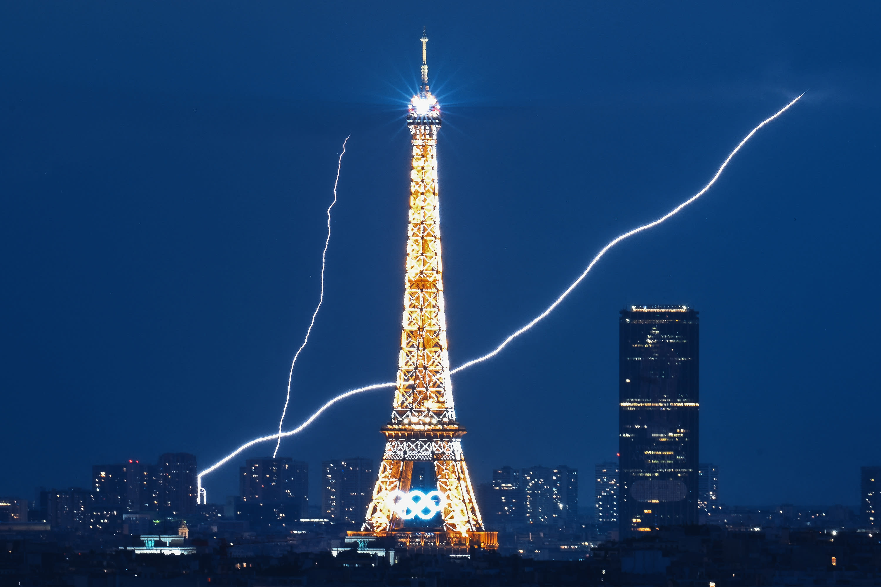 A lightning strike is seen close to the Eiffel Tower during the Paris 2024 Olympic Games in Paris on August 1, 2024. (Photo by LUIS ROBAYO/AFP via Getty Images)
