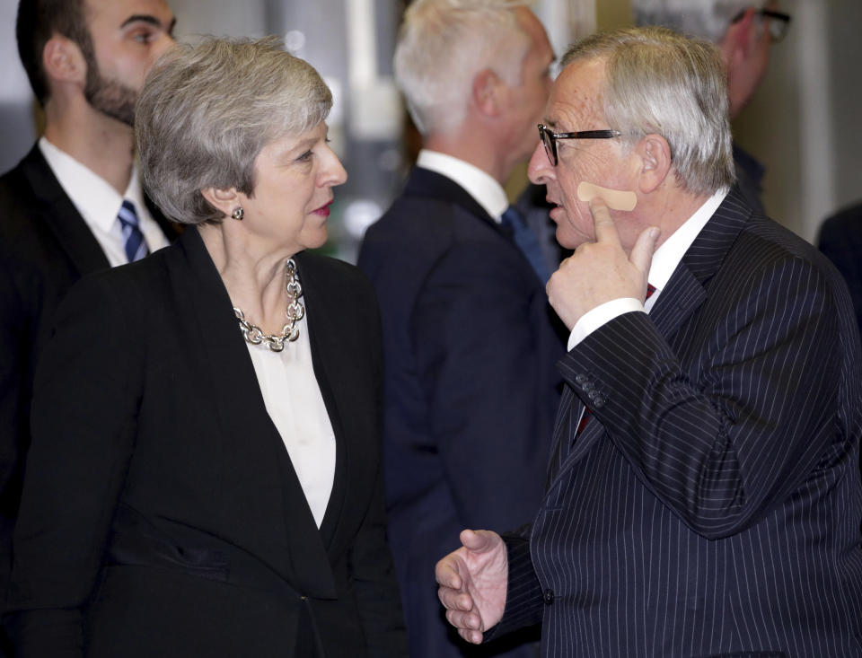 European Commission President Jean-Claude Juncker, right, points to a band aid on his cheek as he speaks with British Prime Minister Theresa May prior to a meeting at EU headquarters in Brussels, Wednesday, Feb. 20, 2019. European Commission President Jean-Claude Juncker and British Prime Minister Theresa May meet Wednesday for their latest negotiating session to seek an elusive breakthrough in Brexit negotiations. (AP Photo/Olivier Matthys)