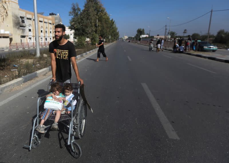 Un hombre palestino evacua con niños desde el norte de la Franja de Gaza hacia el sur, en medio del conflicto en curso entre Israel y el grupo islamista palestino Hamás, en el centro de la Franja de Gaza