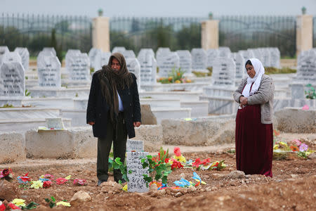 A woman reacts at a grave of her daughter, an SDF fighter killed during fightings with Islamic State militants, at a cemetery in Kobani, Syria April 4, 2019. REUTERS/Ali Hashisho