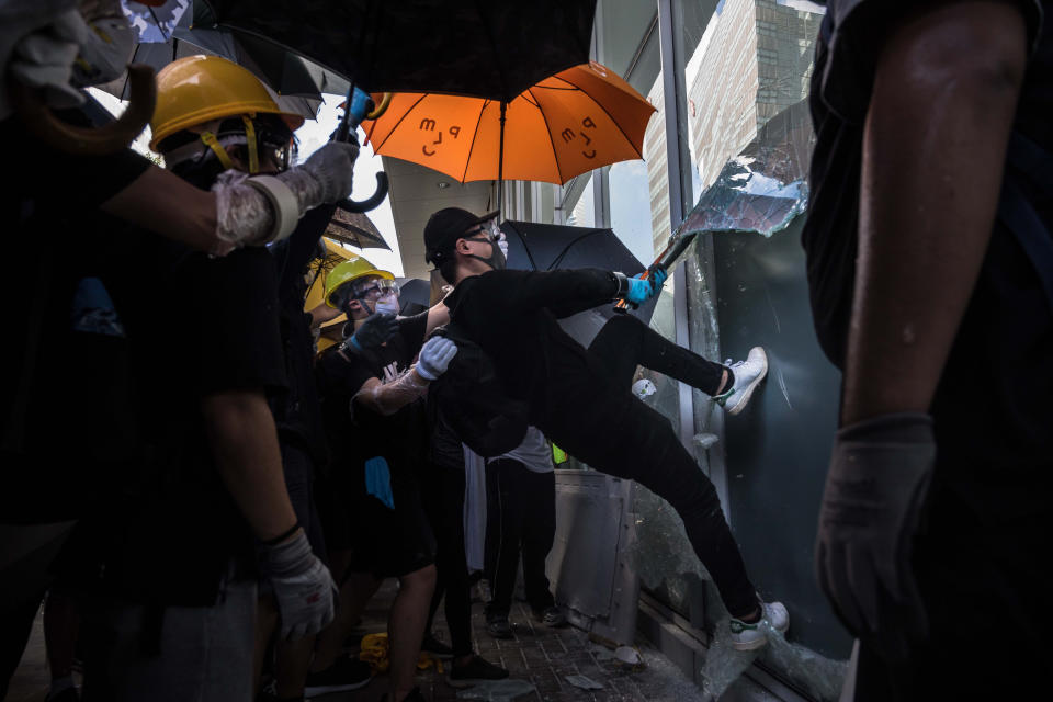 HONG KONG, HONG KONG - JULY 01: Protesters smash glass doors and windows to break into the parliament chamber of Legislative Council Complex protest against the extradition bill on July 1, 2019 in Hong Kong, China. Thousands of pro-democracy protesters faced off with riot police on Monday during the 22nd anniversary of Hong Kong's return to Chinese rule as riot police officers used batons and pepper spray to push back demonstrators. The city's embattled leader Carrie Lam watched a flag-raising ceremony on a video display from inside a convention centre, citing bad weather, as water-filled barricades were set up around the exhibition centre.(Photo by Billy H.C. Kwok/Getty Images)