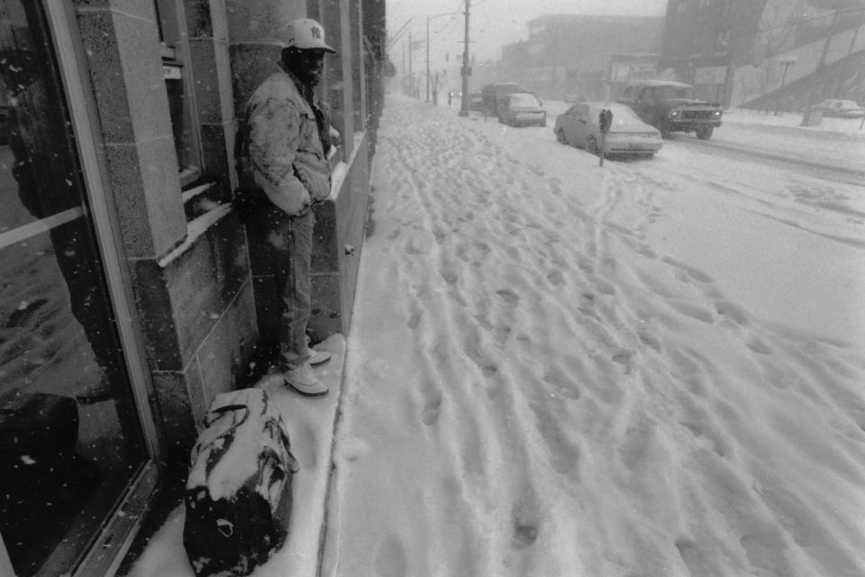 A pedestrian seeks shelter near a building during a large blizzard on March 14, 1993.