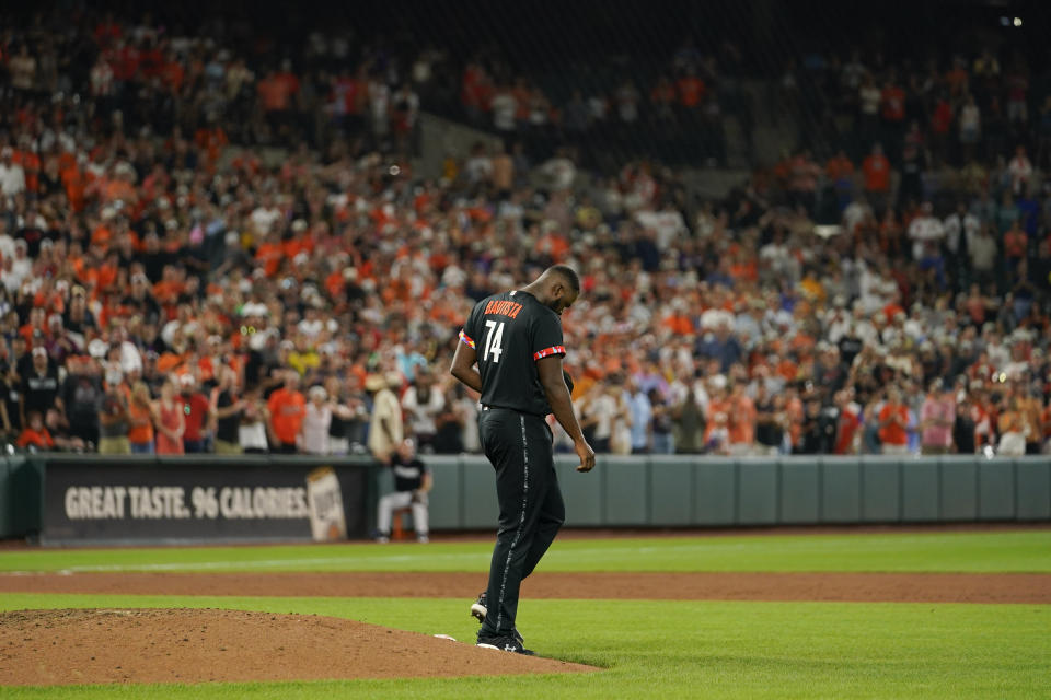 Baltimore Orioles relief pitcher Felix Bautista reacts behind the mound after throwing a pitch to Colorado Rockies pinch hitter Michael Toglia during the ninth inning of a baseball game, Friday, Aug. 25, 2023, in Baltimore. The Orioles won 5-4. Bautista left the game moments later. (AP Photo/Julio Cortez)