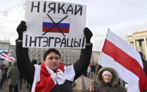A protester holds a banner reading 'No to integration!' during a rally in downtown Minsk, Belarus, Saturday, Dec. 7, 2019. More than 1,000 opposition demonstrators are rallying in Belarus to protest closer integration with Russia. Saturday's protest in the Belarusian capital comes as Belarusian President Alexander Lukashenko is holding talks with Russian President Vladimir Putin in Sochi on Russia's Black Sea coast. (AP Photo/Sergei Grits)