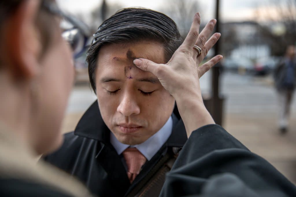 priest putting ashes on man's forehead