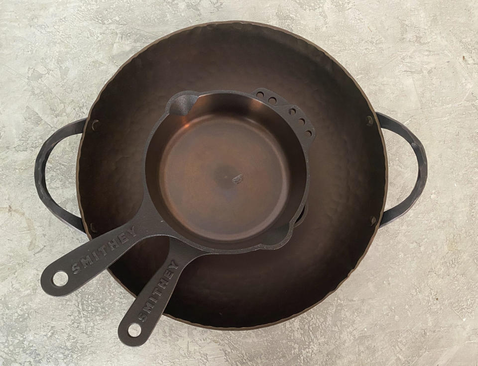 A Smithey round roaster and cast-iron mini skillets appear in New York. The carbon-steel pans are so beautiful you might want to leave them out on the stove. (Katie Workman via AP)