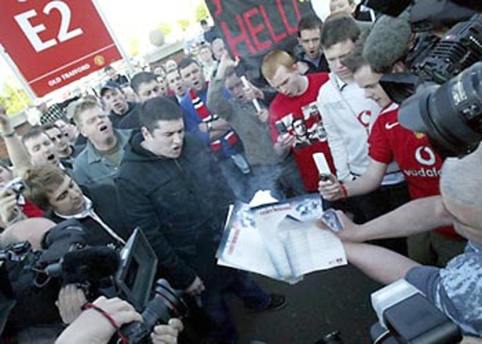 Disgruntled Manchester United supporters burn letters from the club about the renewal of their season tickets.<br></br> Â© PA: 