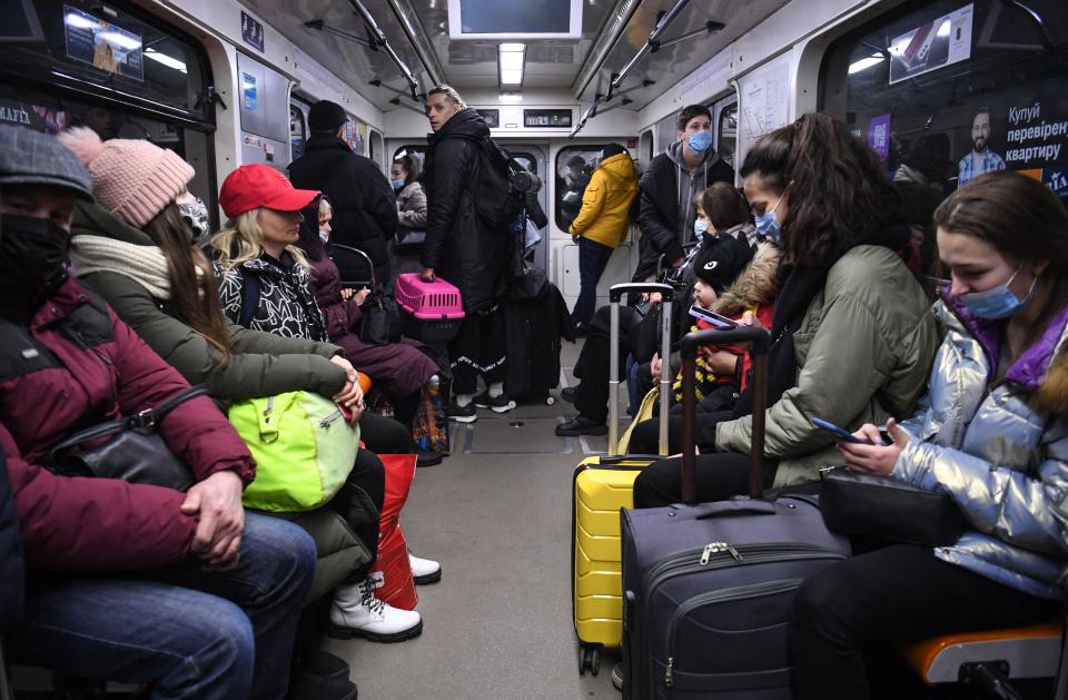 A metro packed with people and their suitcases.