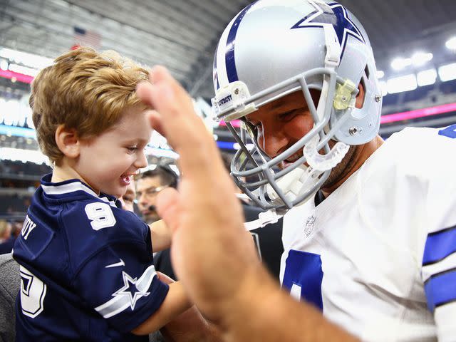 Tom Pennington/Getty Dallas Cowboys quarterback Tony Romo with his son Hawkins Romo on the sidelines of a football game.