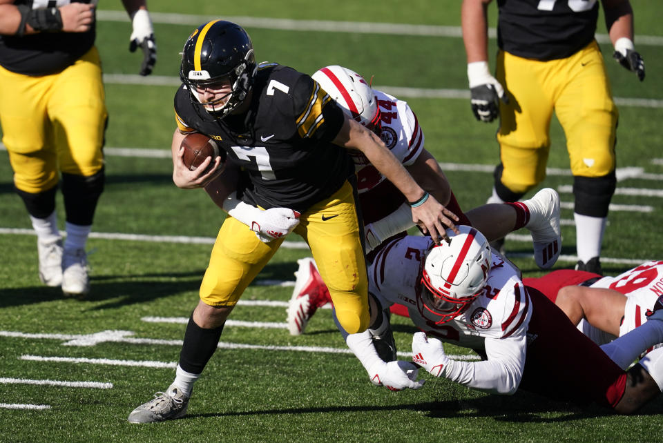 Iowa quarterback Spencer Petras (7) is tackled by Nebraska linebacker Caleb Tannor (2) and linebacker Garrett Nelson (44) during the first half of an NCAA college football game, Friday, Nov. 27, 2020, in Iowa City, Iowa. (AP Photo/Charlie Neibergall)