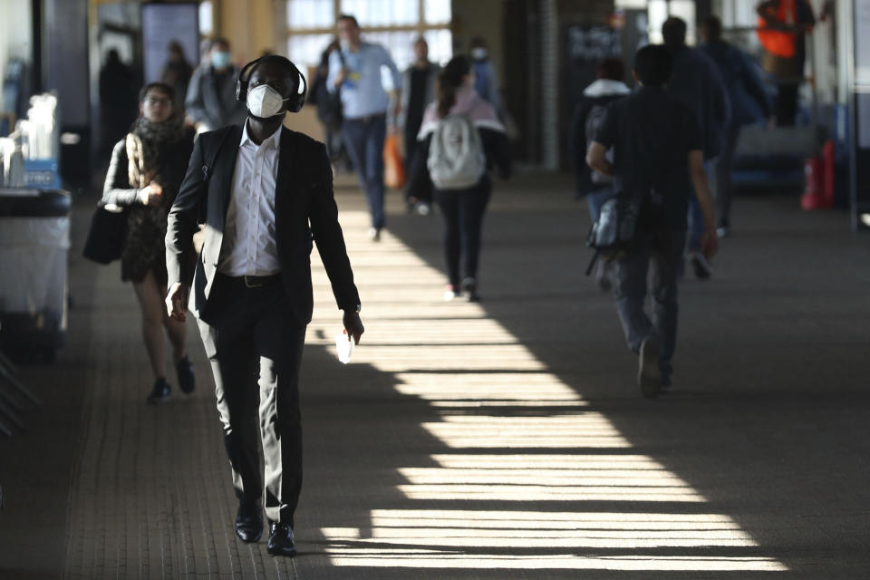 Commuters at Clapham Junction station as train services increased as part of the easing of coronavirus lockdown restrictions, in London, Monday May 18, 2020.Britain's Prime Minister Boris Johnson announced last Sunday that people could return to work if they could not work from home. (Yui Mok/PA via AP)