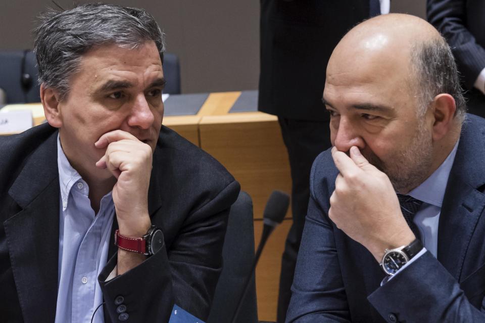 European Commissioner for Economic and Financial Affairs Pierre Moscovici, right, talks with Greece's Finance Minister Euclid Tsakalotos during a round table meeting of EU finance ministers at the EU Council building in Brussels on Friday, Jan. 27, 2017. (AP Photo/Geert Vanden Wijngaert)