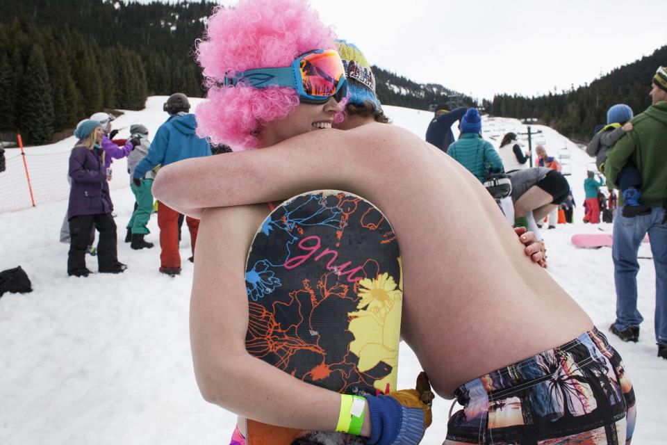 Claire McGuire (L) gets a hug after winning the women's snowboard division of the Bikini & Board Shorts Downhill at Crystal Mountain, a ski resort near Enumclaw, Washington April 19, 2014. Skiers and snowboarders competed for a chance to win one of four season's passes. REUTERS/David Ryder (UNITED STATES - Tags: SPORT SOCIETY)