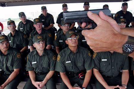 Trainees from Class 628 listen to U.S. Border Patrol agent and Class IV supervisor James Joseph Holler as he instructs them on the proper grip and safe use of their Heckler & Koch P2000 handgun during the trainees first day on the firing range at the U.S. Border Patrol Training Academy in Artesia, New Mexico, August 18, 2006. REUTERS/Jeff Topping/File Photo