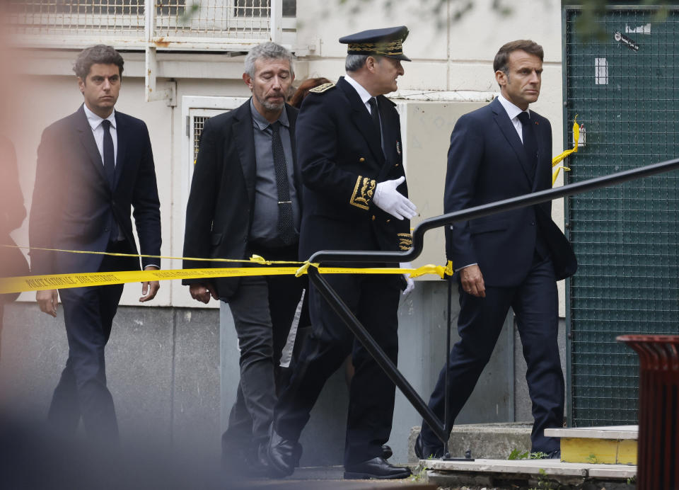 French President Emmanuel Macron, right, and Education Minister Gabriel Attal, left, arrive at the Gambetta high school in Arras, northeastern France, Friday Oct. 13, 2023. A man of Chechen origin who was under surveillance by the French security services stabbed a teacher to death at his former high school and critically wounded two other people in northern France on Friday, authorities said. (Ludovic Marin, Pool via AP)