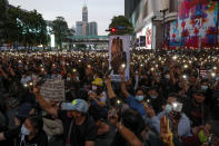 Pro-democracy activists wave their mobile phone flash lights during a protest rally at Ratchaprasong business district in Bangkok, Thailand, Sunday, Oct. 25, 2020. Pro-democracy protesters in Thailand gathered again Sunday in Bangkok, seeking to keep up pressure on the government a day ahead of a special session of Parliament called to try to ease political tensions.(AP Photo/Gemunu Amarasinghe)