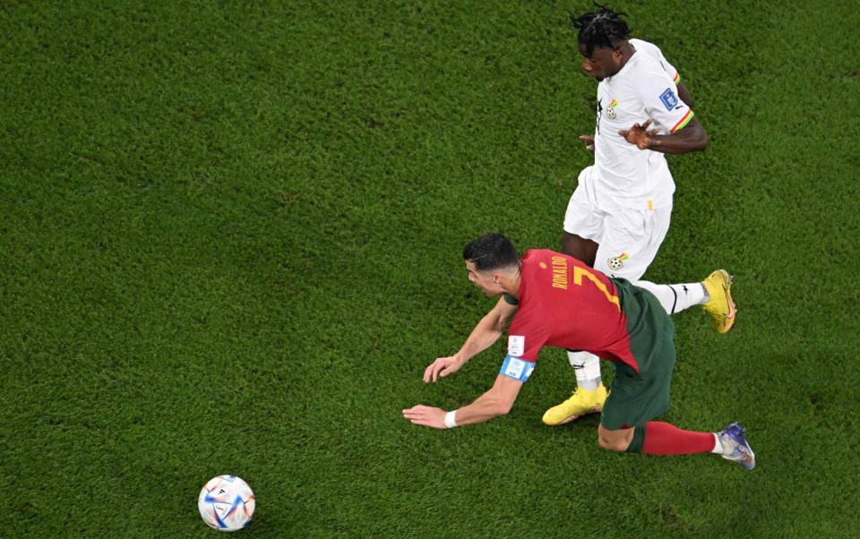hana's defender #04 Mohammed Salisu fouls Portugal's forward #07 Cristiano Ronaldo in the area to commit a penalty during the Qatar 2022 World Cup Group H football match between Portugal and Ghana at Stadium 974 in Doha on November 24, 2022. - KIRILL KUDRYAVTSEV/AFP via Getty Image