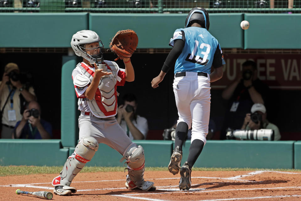 Curacao's Jurdrick Profar (13) scores on a throwing error at third base, ahead of the throw to Japan's Jo Nishizawa (10) in the first inning International Championship baseball game at the Little League World Series tournament in South Williamsport, Pa., Saturday, Aug. 24, 2019. (AP Photo/Gene J. Puskar)