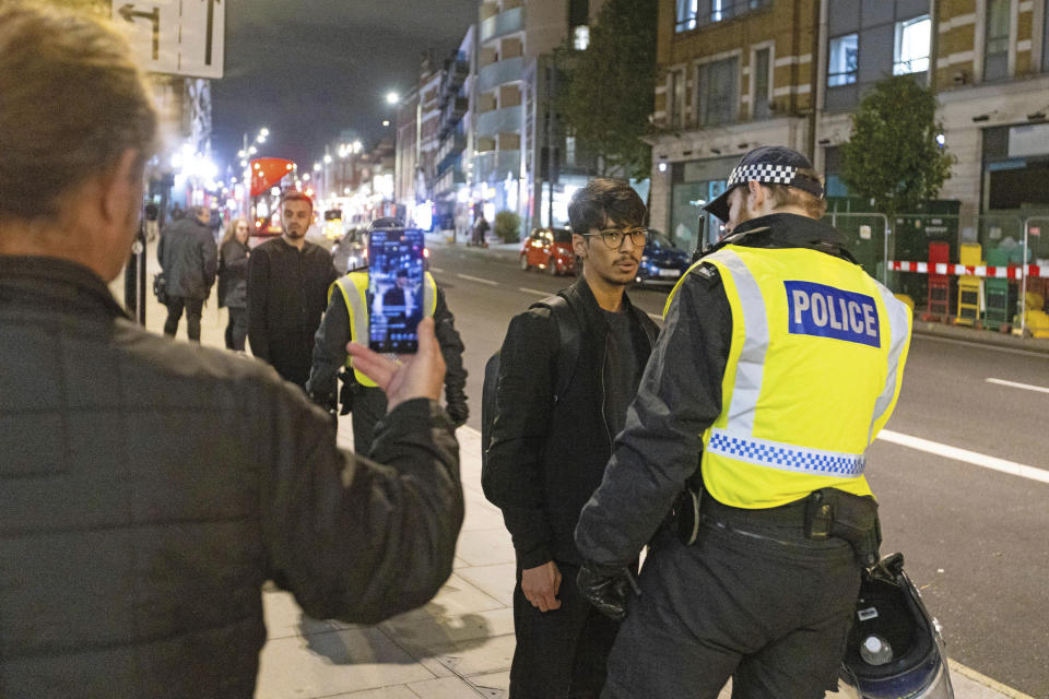 Protesters are asked to leave the area after clashes with police outside the Kilburn Islamic Centre in London, Sunday, Sept. 25, 2022. They were protesting against the death of Iranian Mahsa Amini, a 22-year-old woman, who died in Iran while in police custody, was arrested by Iran's morality police for allegedly violating its strictly-enforced dress code. (David Parry/PA via AP)