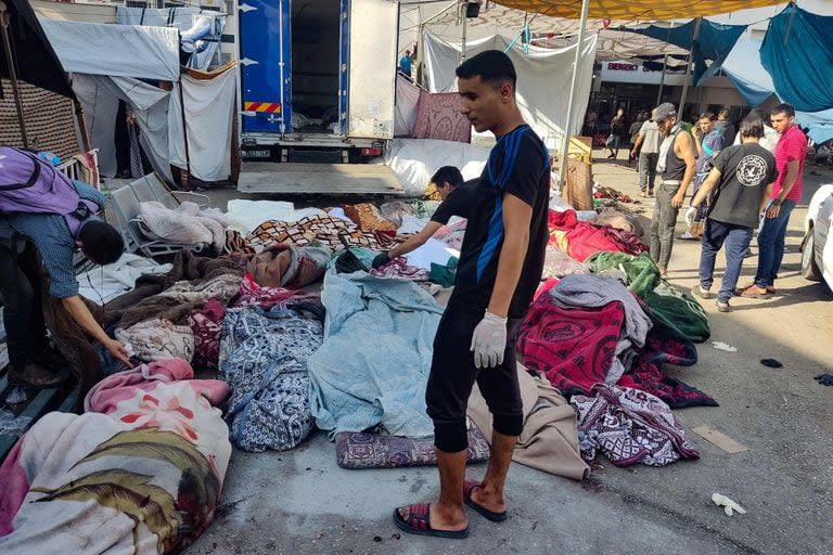 Los cuerpos de palestinos muertos en el ataque a una escuela de Gaza, yacen en e patio del hospital Al-Shifa (Photo by Khoder al-Zaanoun / AFP)