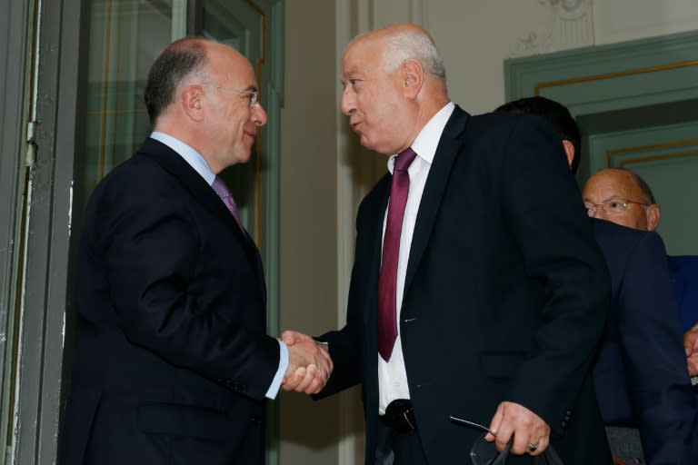 French Interior Minister Bernard Cazeneuve (L) shakes hands with the general secretary of the French Council of Muslim Faith Abdallah Zekri on August 29, 2016 in Paris