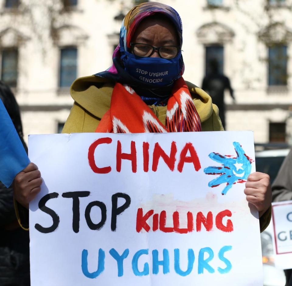 A Uyghur woman during a demonstration in Parliament Square, London (PA)