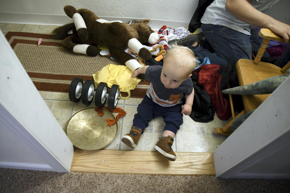 Cal Sabey, 1, plays at a relative's home in Centennial, Colo., Wednesday, May 3, 2023. His parents, Sarah Perkins and Joshua Sabey, are suing police and social workers in Massachusetts after their two young children were taken by the state's Department of Children and Families in July 2022. Hospital staff discovered that Cal had suffered a broken rib and flagged the couple for possible child abuse. The couple's lawsuit alleges constitutional violations including the unreasonable search of their house, the unreasonable seizure of their children and the deprivation of parental rights without due process. (AP Photo/Thomas Peipert)