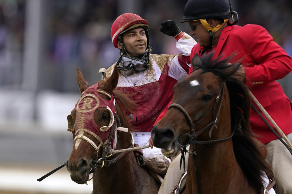 Sonny Leon celebrates after riding Rich Strike past the finish line to win the 148th running of the Kentucky Derby horse race at Churchill Downs Saturday, May 7, 2022, in Louisville, Ky. (AP Photo/Charlie Neibergall)