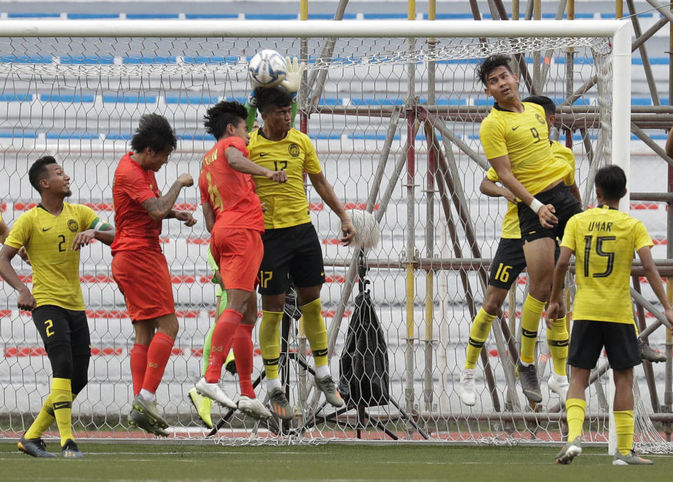 Malaysia's Muhammad Irfan Zakaria, center, defends the goal against Myanmar during their first round Group A football match at the 30th South East Asian Games in Manila, Philippines on Monday, Nov. 25, 2019. The Philippines is hosting the SEA games which officially starts Nov. 30 - Dec. 11. (AP Photo/Aaron Favila)