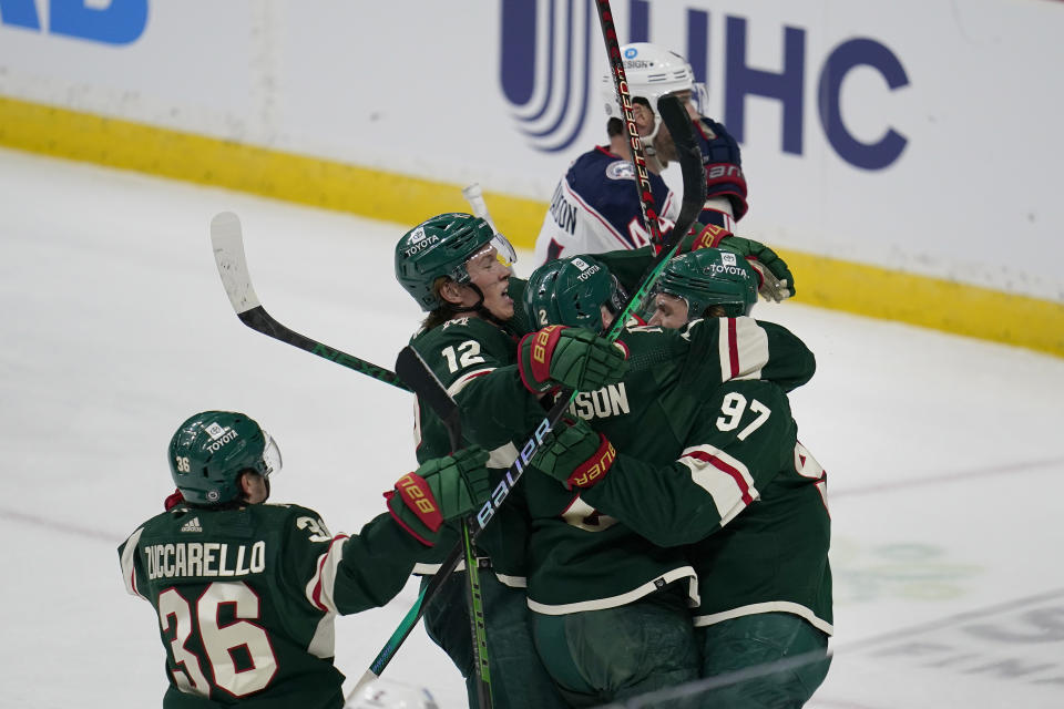 Minnesota Wild left wing Kirill Kaprizov (97), right, celebrates with teammates after scoring his second goal against the Columbus Blue Jackets during the third period of an NHL hockey game Sunday, Feb. 26, 2023, in St. Paul, Minn. (AP Photo/Abbie Parr)