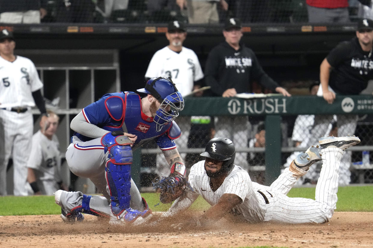 Chicago White Sox's Elvis Andrus, right, scores against Texas Rangers catcher Jonah Heim during the eighth inning of a baseball game in Chicago, Tuesday, June 20, 2023. The White Sox won 7-6. (AP Photo/Nam Y. Huh)