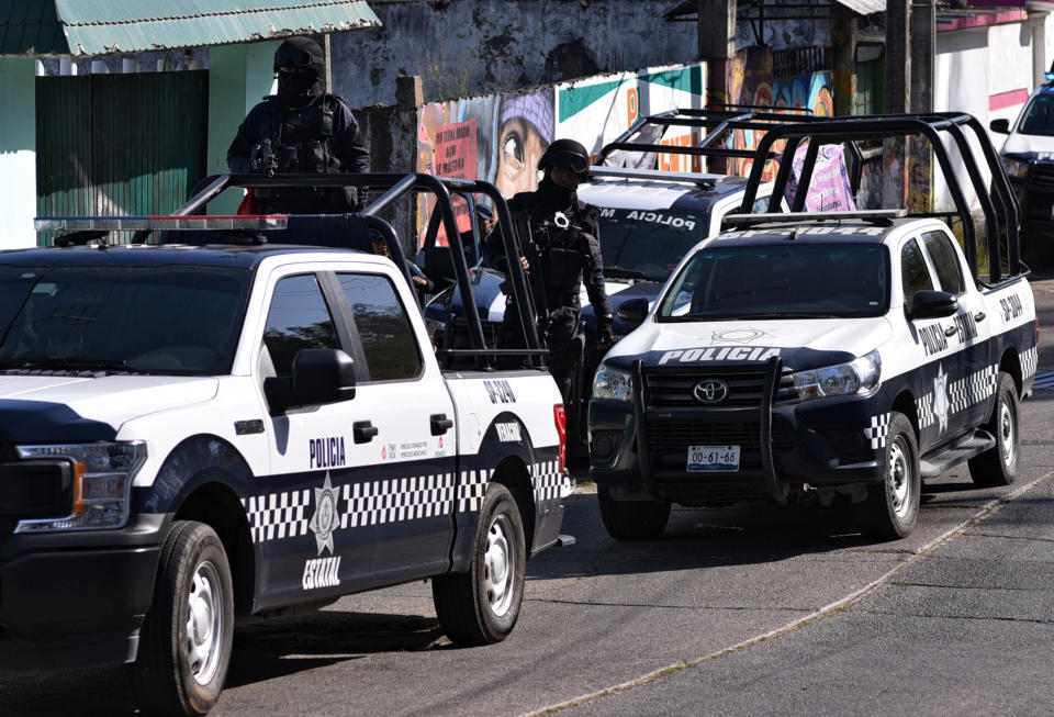 La policía del estado de Veracruz monta guardia fuera de la casa donde 13 personas fueron asesinadas a tiros, el 20 de abril de 2019 en Minatitlán, México