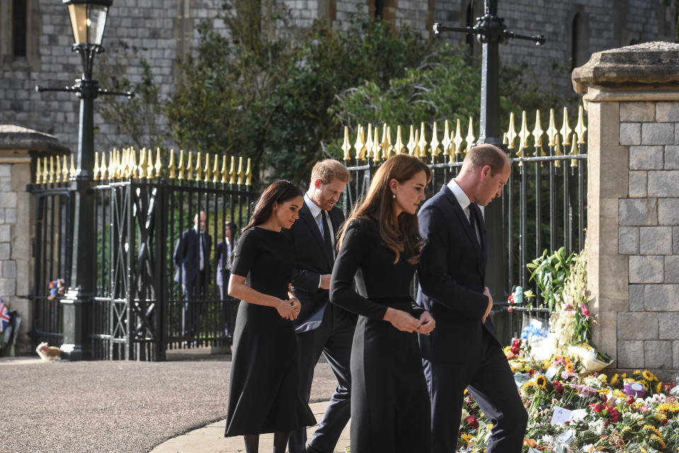 Meghan y el príncipe Enrique, a la izquierda, acompañan al príncipe Guillermo y Catalina para ver los homenajes que dejó el público a la difunta reina Isabel II, afuera del castillo de Windsor en Inglaterra el sábado 10 de septiembre de 2022. (Mary Turner/The New York Times)