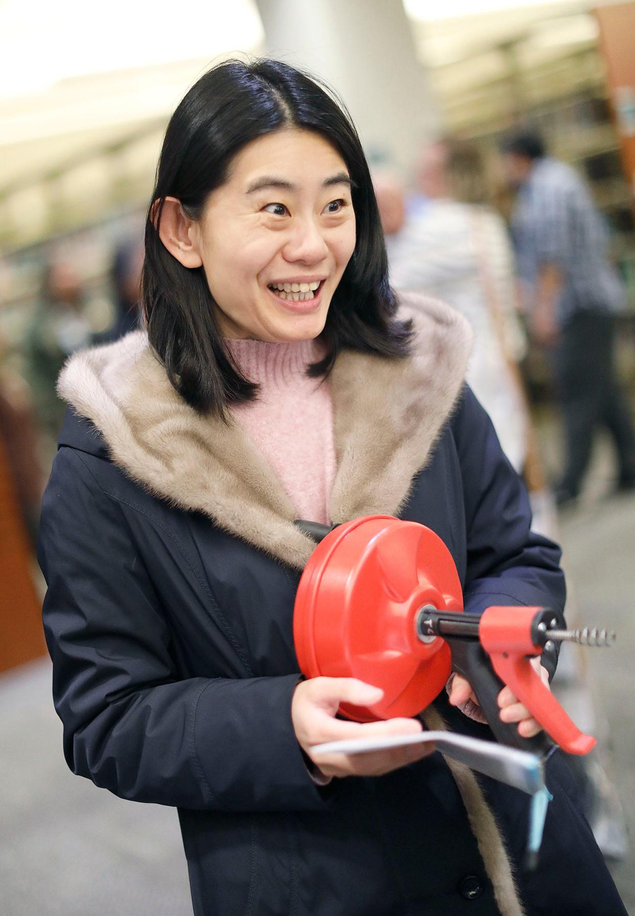 Flora Han, of Quincy Center, is borrowing a drain unclogging tool at the Library of Things at the Thomas Crane Public Library in Quincy on Wednesday, Jan. 31, 2024.