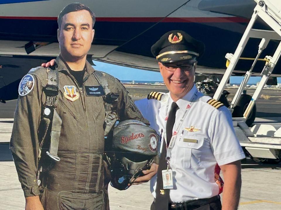 Delta pilot Keith Rosenkranz poses with a large cut-out of himself as a fighter pilot in the Air Force.