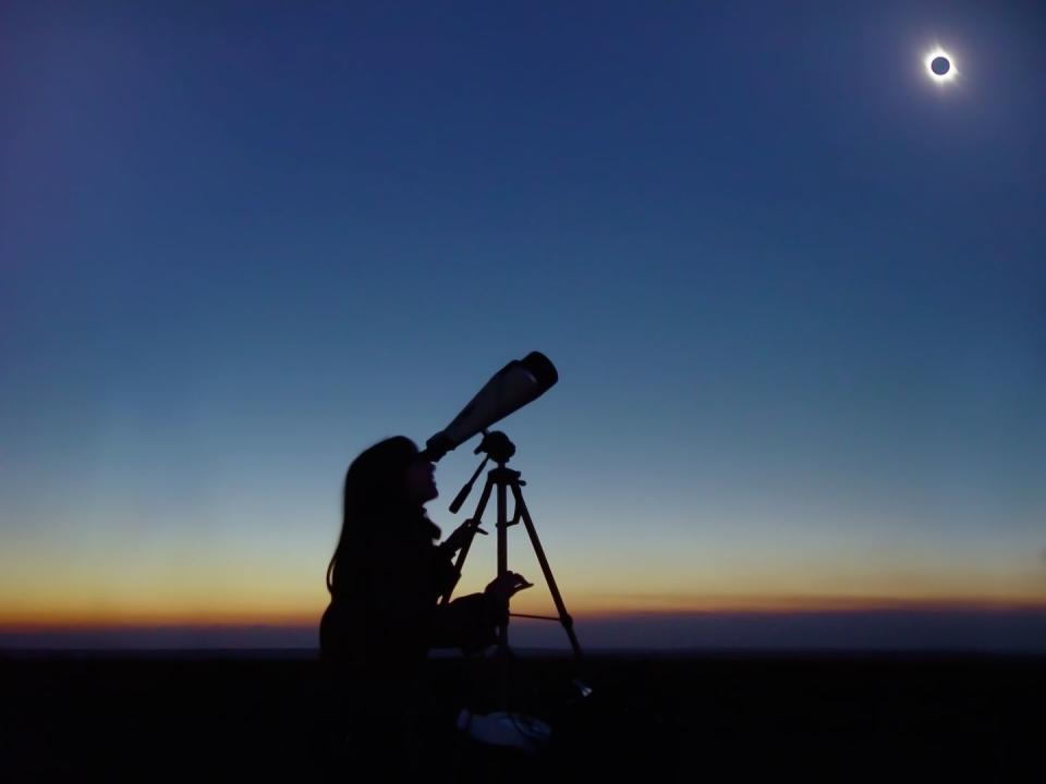 young woman observing total solar eclipse