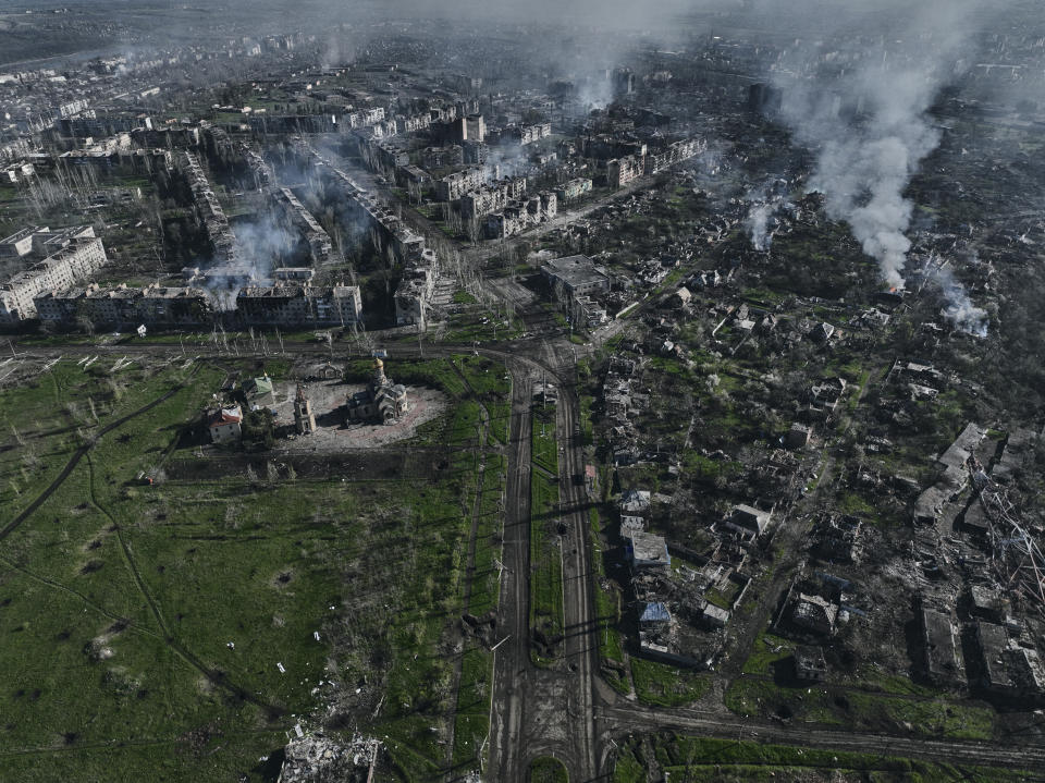 FILE - Smoke rises from buildings in this aerial view of Bakhmut, the site of the heaviest battles with the Russian troops in the Donetsk region, Ukraine, Wednesday, April 26, 2023. Ukrainian President Volodymyr Zelenskyy said Sunday, May 21, 2023 that Russian forces weren't occupying Bakhmut, casting doubt on Moscow's insistence that the eastern Ukrainian city had fallen. The fog of war made it impossible to confirm the situation on the ground in the invasion’s longest battle, and the comments from Ukrainian and Russian officials added confusion to the matter. (AP Photo/Libkos, File)