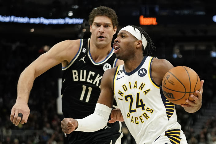 Indiana Pacers' Buddy Hield drives to the basket against Milwaukee Bucks' Brook Lopez during the first half of an NBA basketball game, Monday, Jan. 16, 2023, in Milwaukee. (AP Photo/Aaron Gash)