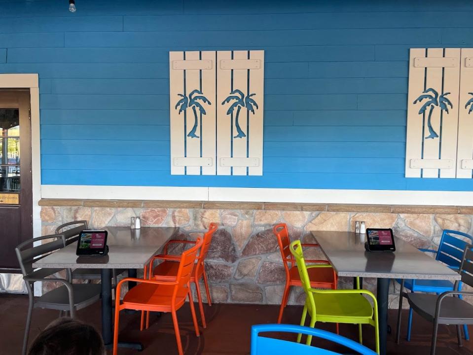 Bahama Breeze blue walls with palm trees and tables with colorful chairs