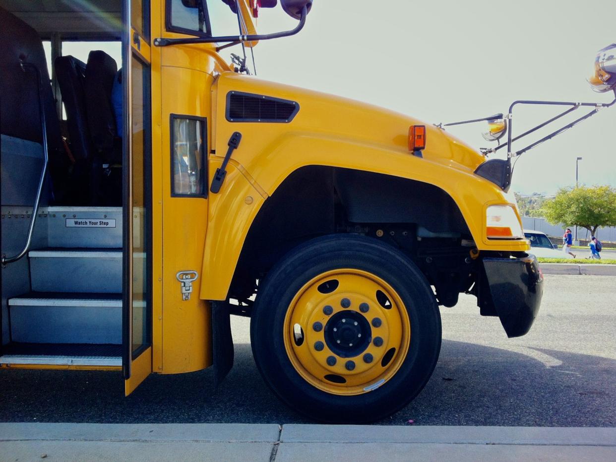 The front of a yellow school bus with the doors open.