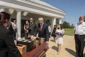 Justine Newman, of Chester, follows the table containing the cremated remains of 14 unclaimed veterans including the nine from Chester County that she identified.