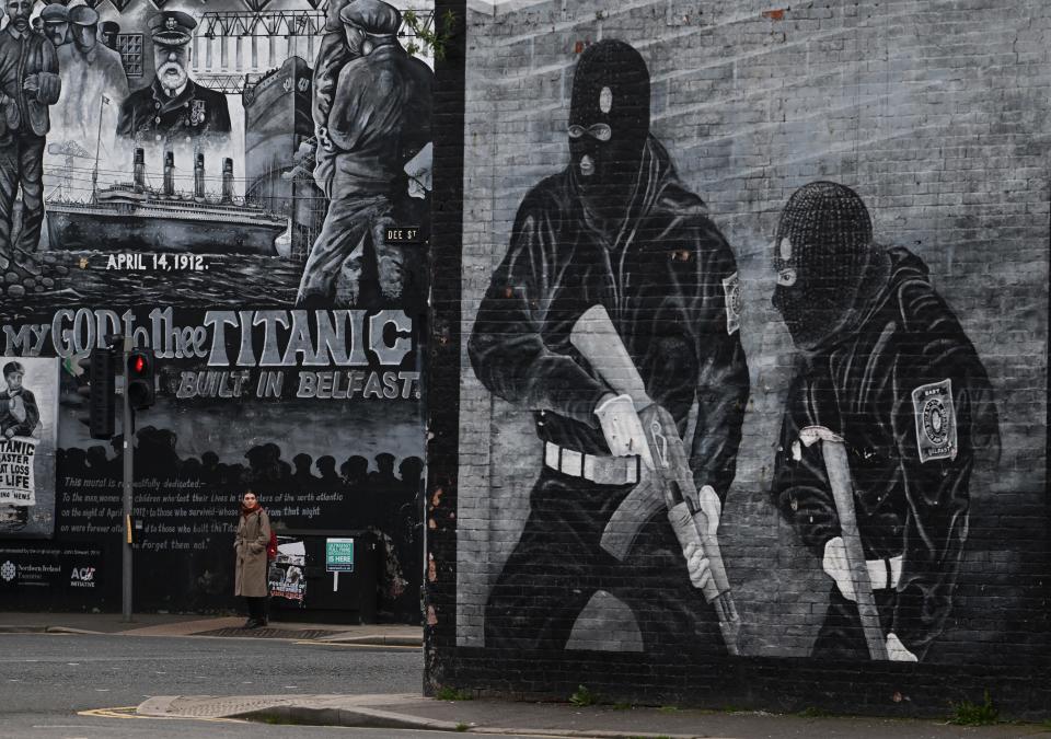 A local resident walks past a loyalist paramilitary mural on April 4, 2023 in Belfast, Northern Ireland. The Good Friday Agreement, signed on April 10, 1998, ended most of the violence during the decades-long conflict known as The Troubles