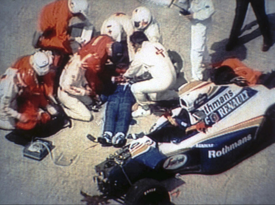 FILE- In this TV image, rescue crew members give first aid to unconscious formula one driver Ayrton Senna, lying mortally injured, beside his wrecked car after the Brazillian driver crashed against the course wall during the Grand Prix of San Marino, in this file photo dated Sunday May 1, 1994, in Imola, Italy. The 30th anniversary of Ayrton Senna’s death is commemorated on Wednesday, May 1, 2024, with a memorial on the Imola track where he crashed during the 1994 San Marino Grand Prix. (AP Photo/File)