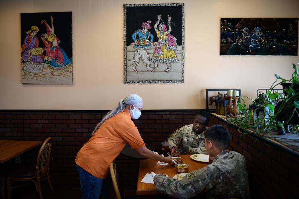 Customer are served their food at Bombay Bistro in the Cliffdale Square shopping plaza on Wednesday, May 5, 2021.