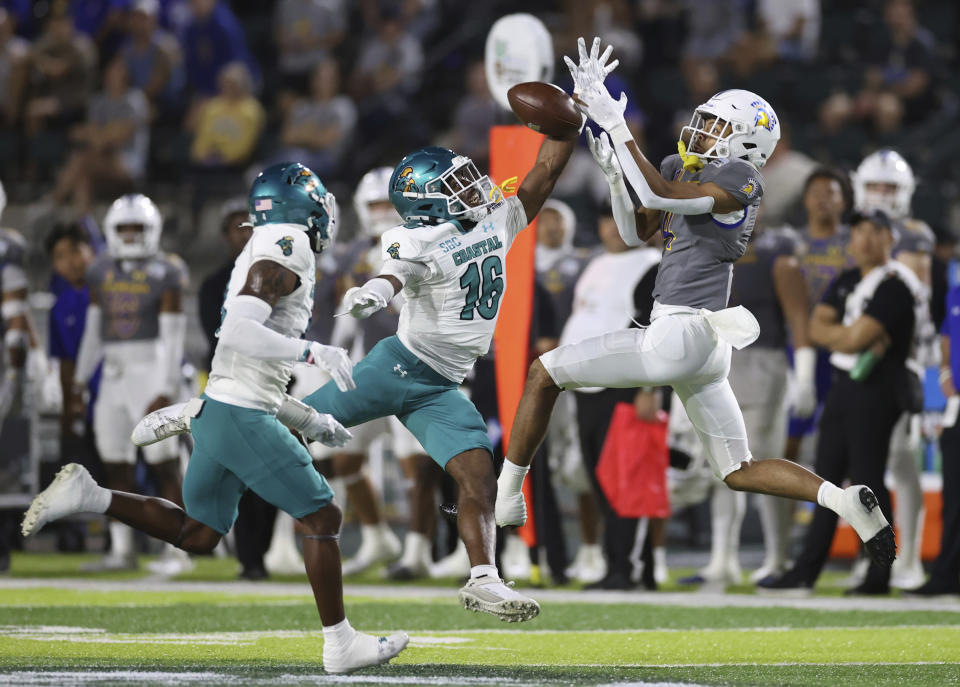 San Jose State wide receiver Charles Ross, , right, can't pull in a pass while being guarded by Coastal Carolina cornerback Matthew McDoom (16) during the first half of the Hawaii Bowl NCAA college football game Saturday, Dec. 23, 2023, in Honolulu. (AP Photo/Marco Garcia)