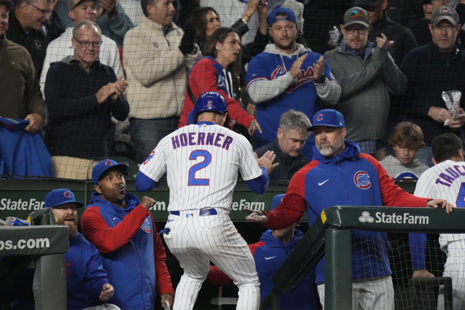 Chicago Cubs' Nico Hoerner (2) celebrates with manager David Ross, right, and coaching staff after scoring on a one-run double by Ian Happ during the fifth inning of a baseball game against the Pittsburgh Pirates in Chicago, Thursday, June 15, 2023. (AP Photo/Nam Y. Huh)